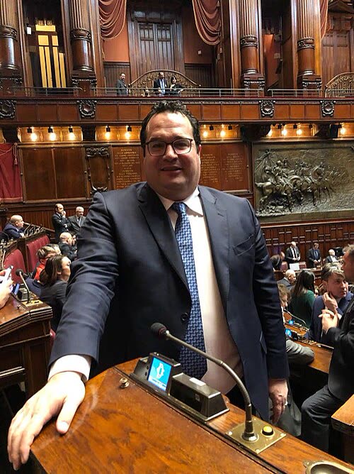 Claudio Durigon in piedi tra i banchi dell'aula della Camera dei deputati